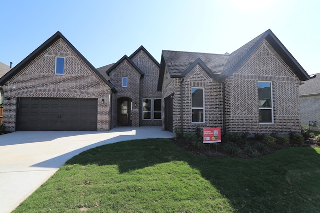 view of front of home with a garage and a front lawn