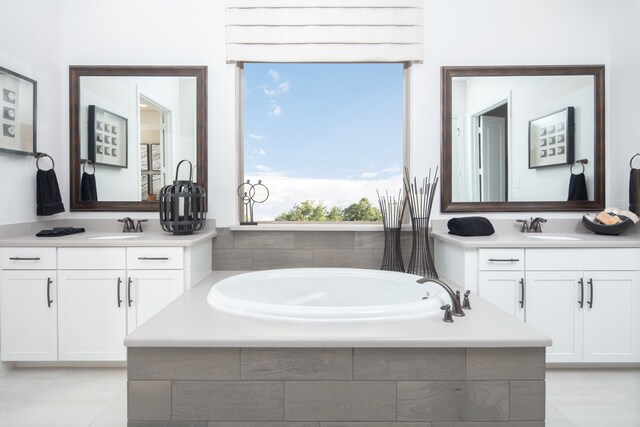 bathroom with vanity and tiled tub