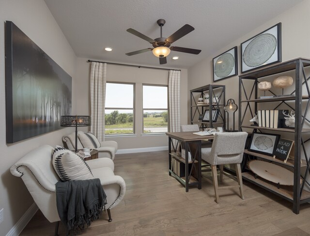 office area with light hardwood / wood-style floors and ceiling fan