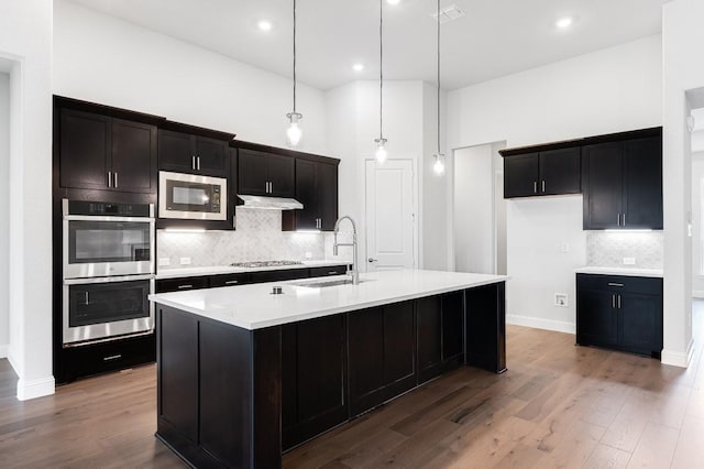 kitchen with visible vents, light countertops, appliances with stainless steel finishes, wood finished floors, and a sink