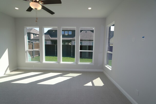 unfurnished sunroom with ceiling fan