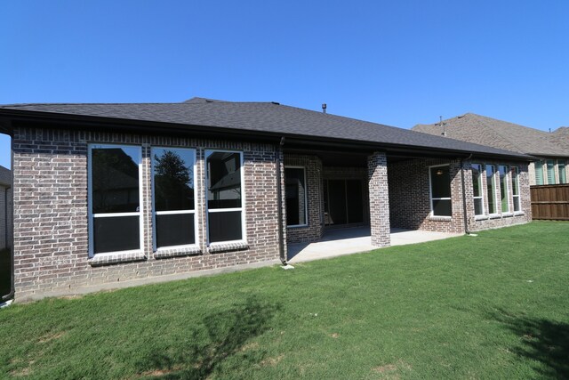 back of house with a patio and a lawn