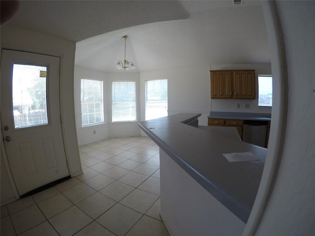 kitchen with an inviting chandelier, dishwasher, light tile patterned floors, and pendant lighting