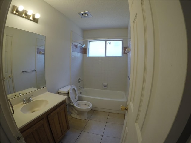 full bathroom featuring tile patterned flooring, vanity, tiled shower / bath combo, toilet, and a textured ceiling