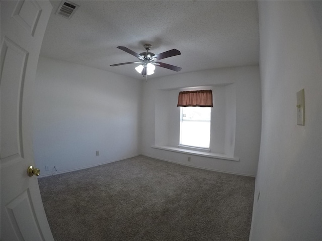 carpeted empty room with ceiling fan and a textured ceiling