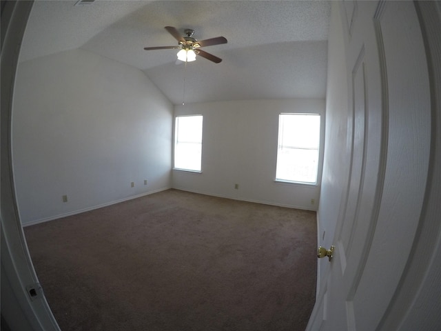 empty room with lofted ceiling, carpet flooring, and ceiling fan