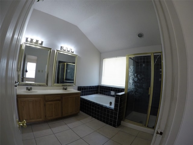 bathroom with tile patterned floors, shower with separate bathtub, vaulted ceiling, and vanity