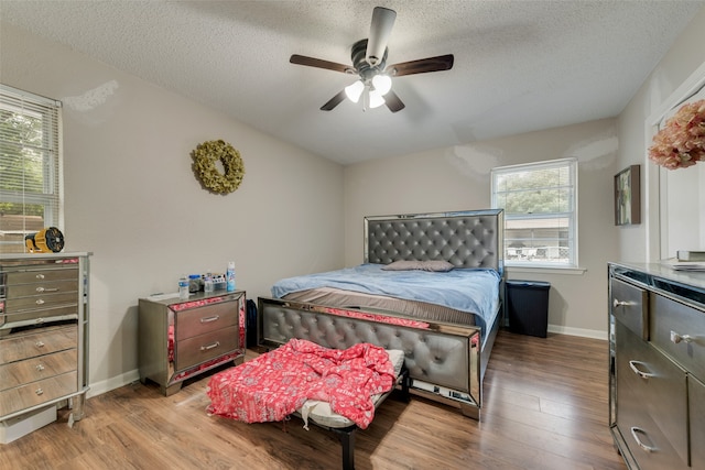 bedroom featuring light hardwood / wood-style flooring, ceiling fan, and a textured ceiling