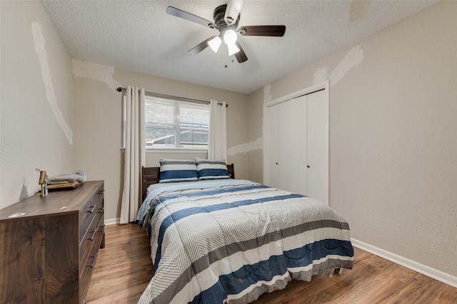 bedroom with a textured ceiling, hardwood / wood-style floors, ceiling fan, and a closet