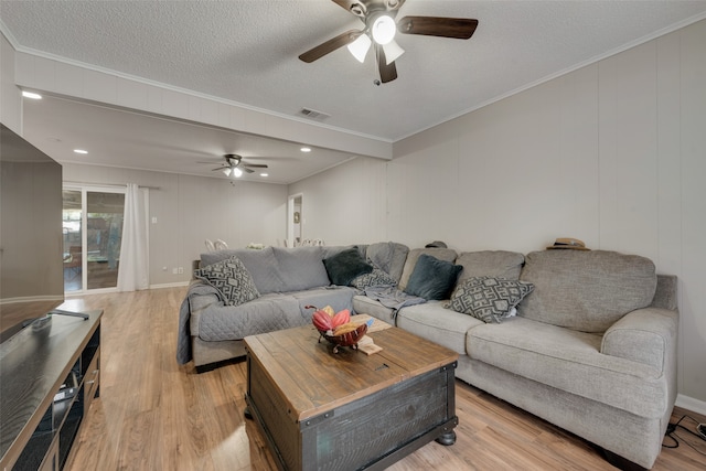 living room with ceiling fan, a textured ceiling, light wood-type flooring, and crown molding