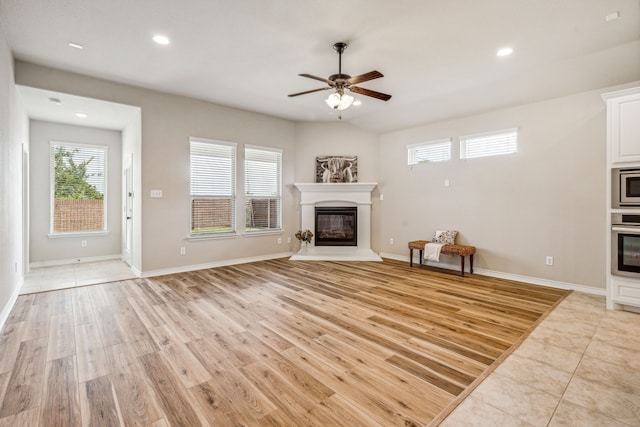 unfurnished living room with ceiling fan and light tile patterned floors