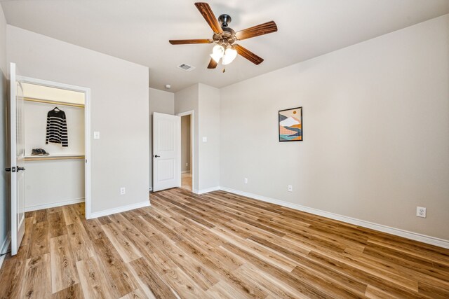 unfurnished bedroom with ceiling fan, light hardwood / wood-style flooring, and a closet