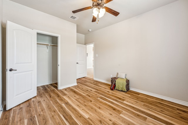 unfurnished bedroom featuring ceiling fan, a closet, and light hardwood / wood-style flooring