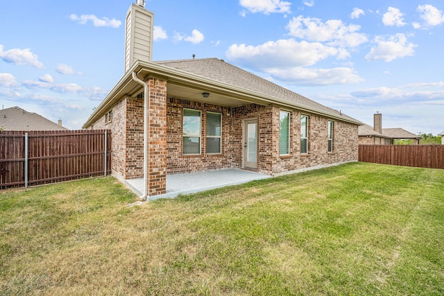 rear view of house with a patio and a lawn