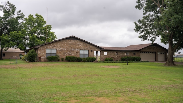 ranch-style house featuring a garage and a front lawn