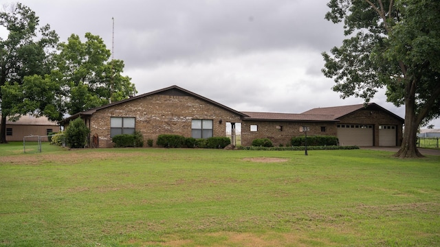 single story home featuring a garage, a front lawn, and brick siding