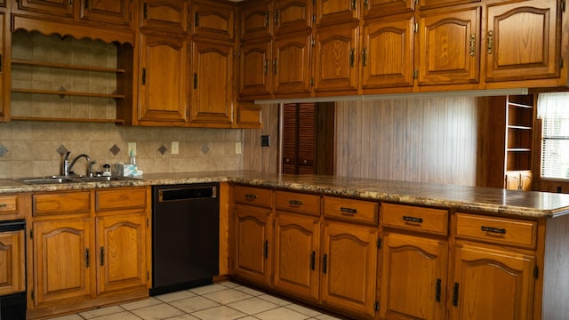 kitchen featuring black dishwasher, a peninsula, a sink, and brown cabinets