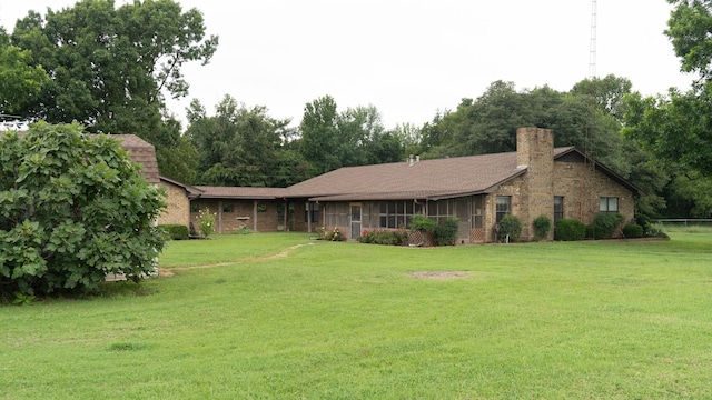 view of front of home with a chimney and a front yard