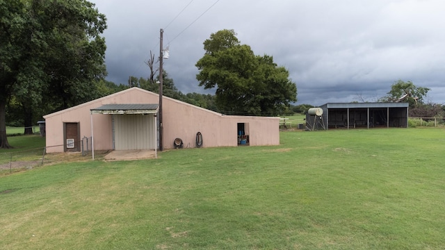 view of yard with fence, an outdoor structure, and an outbuilding