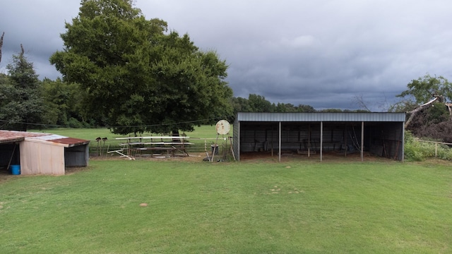 view of yard with a carport, an outbuilding, an outdoor structure, and fence