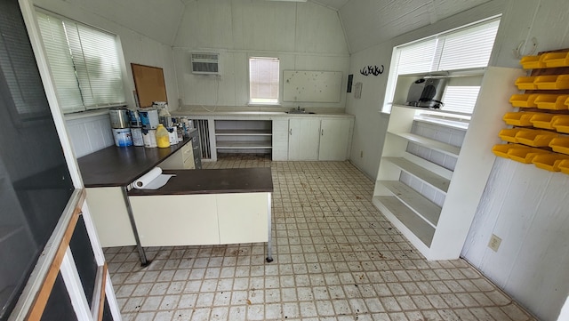 kitchen featuring light tile patterned flooring, an AC wall unit, and white cabinets