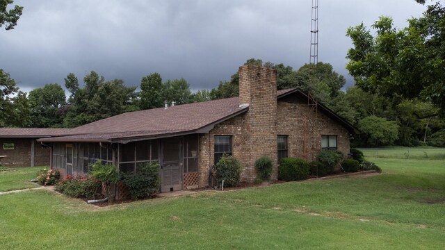 view of property exterior featuring a sunroom and a yard