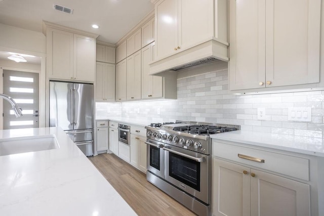 115 Palisades Dr, Gordonville, TX 76245 - kitchen with sink, backsplash, high quality appliances, light stone countertops, and light hardwood / wood-style floors