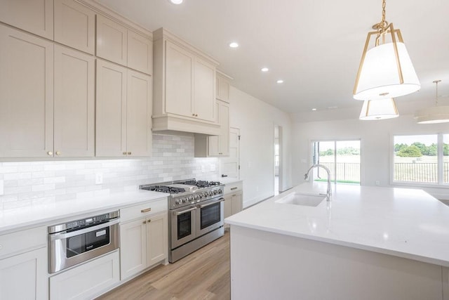 115 Palisades Dr, Gordonville, TX 76245 - kitchen featuring sink, a kitchen island with sink, double oven range, tasteful backsplash, and decorative light fixtures