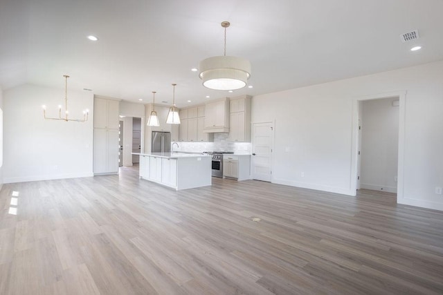 115 Palisades Dr, Gordonville, TX 76245 - kitchen with a kitchen island, appliances with stainless steel finishes, pendant lighting, backsplash, and light hardwood / wood-style floors