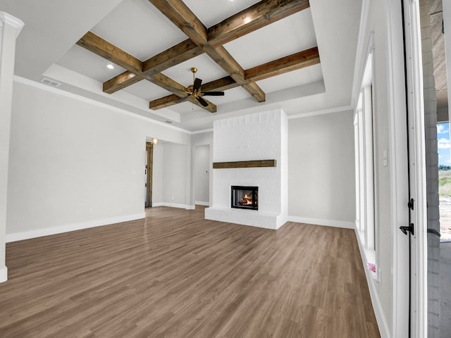 unfurnished living room with visible vents, coffered ceiling, wood finished floors, baseboards, and a brick fireplace