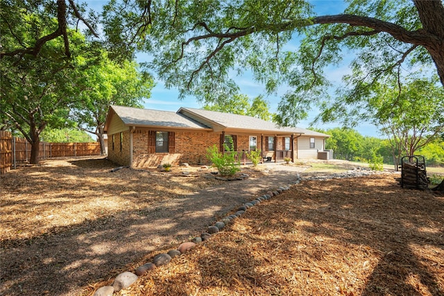 view of front of property featuring brick siding and fence