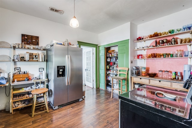 kitchen featuring stainless steel refrigerator with ice dispenser, dark hardwood / wood-style floors, pendant lighting, and electric range oven