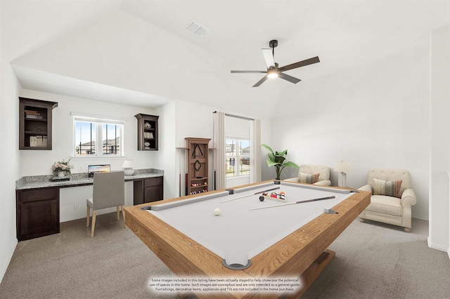 recreation room with a wealth of natural light, vaulted ceiling, built in desk, and light colored carpet