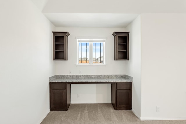 unfurnished office with light colored carpet and built in desk