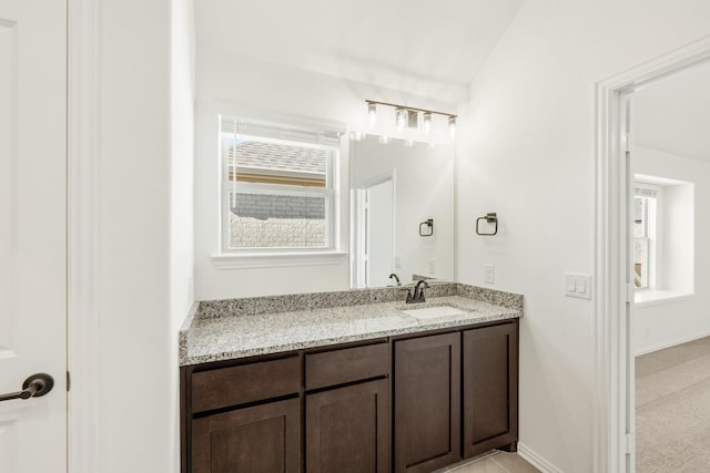 bathroom featuring vanity and lofted ceiling