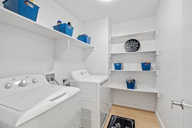 washroom with light hardwood / wood-style floors and washer and clothes dryer