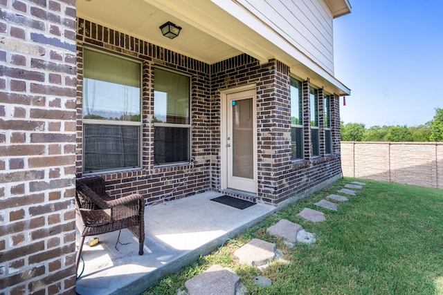 property entrance with a lawn and a patio area