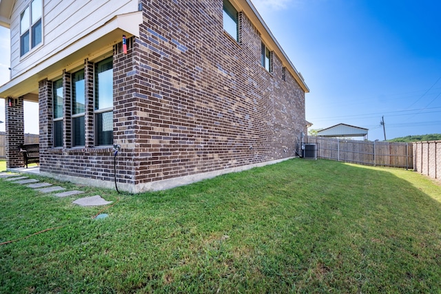 view of property exterior with a lawn and central air condition unit