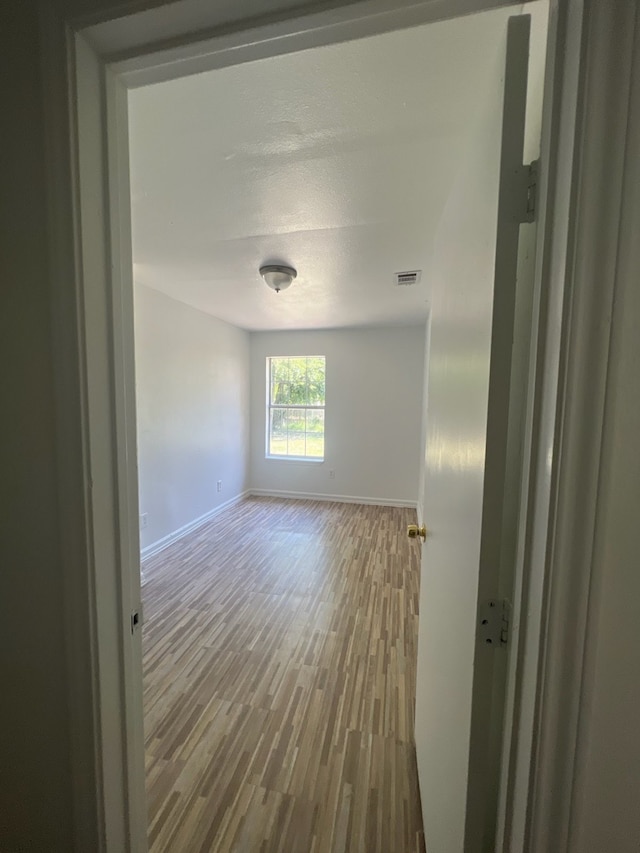 unfurnished room with wood-type flooring