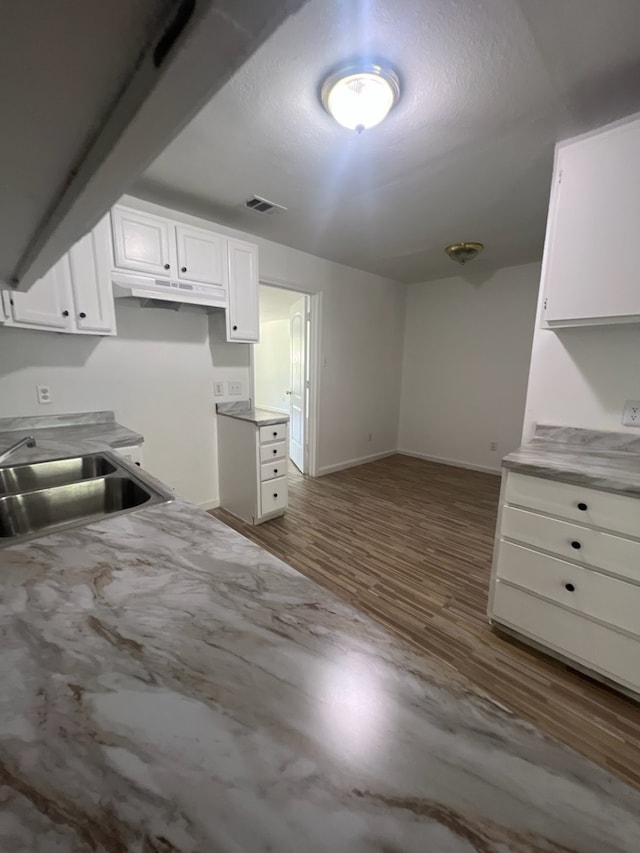 kitchen with white cabinets, sink, and hardwood / wood-style floors