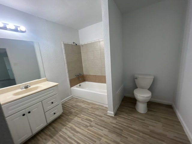 full bathroom with tiled shower / bath combo, hardwood / wood-style flooring, vanity, and toilet