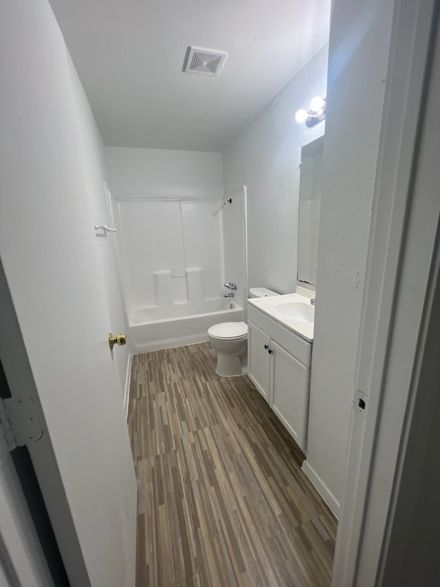 full bathroom with wood-type flooring, shower / washtub combination, vanity, and toilet