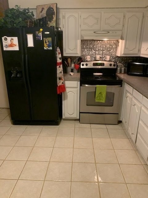 kitchen featuring black fridge with ice dispenser, tasteful backsplash, light tile patterned flooring, and stainless steel range with electric stovetop