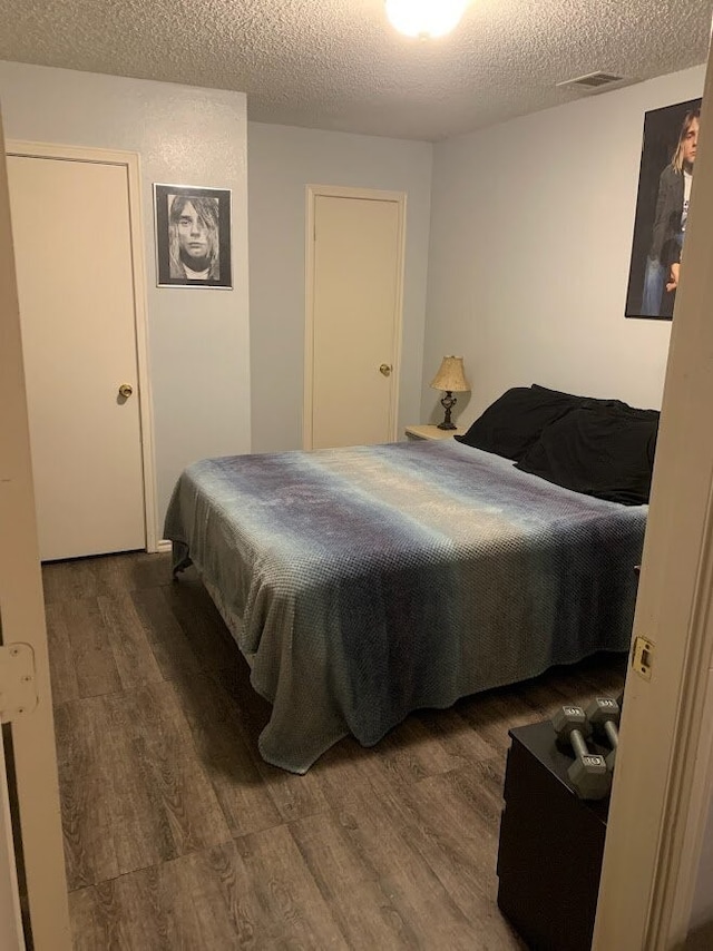 bedroom with hardwood / wood-style flooring and a textured ceiling