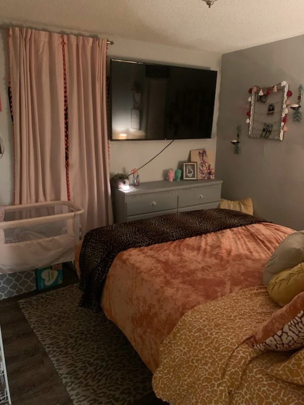 bedroom with wood-type flooring and a textured ceiling