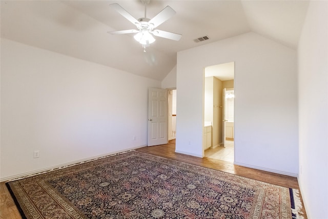 unfurnished bedroom with ensuite bath, light hardwood / wood-style flooring, ceiling fan, and lofted ceiling