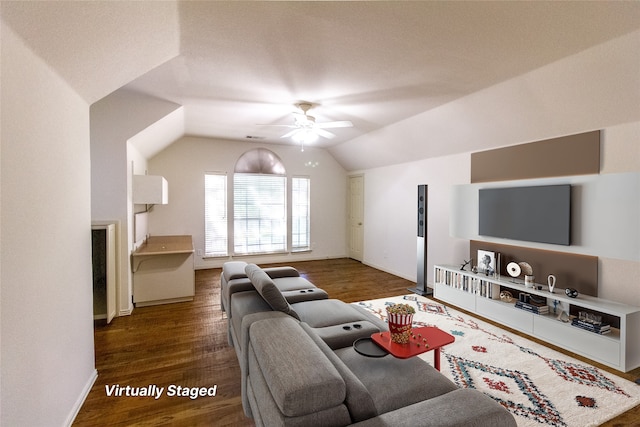 living room featuring ceiling fan, dark wood-type flooring, and vaulted ceiling