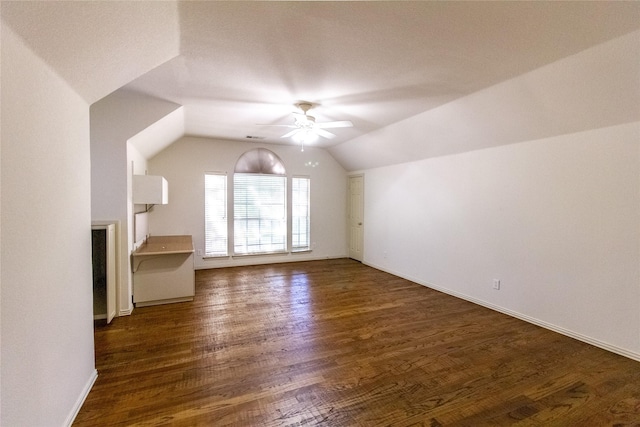 additional living space featuring ceiling fan, dark wood-type flooring, and vaulted ceiling