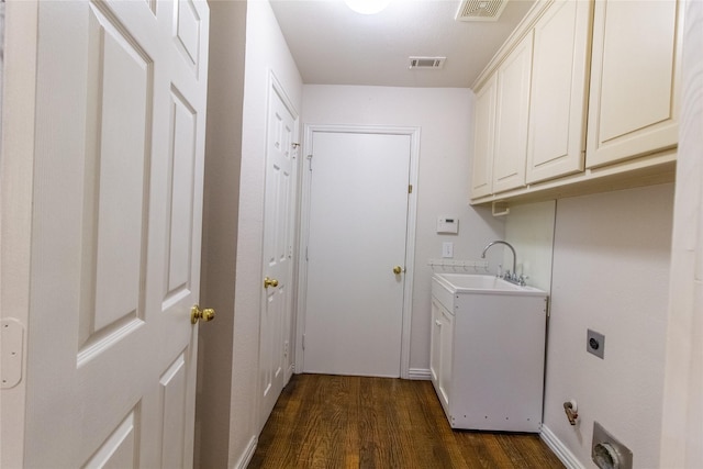 laundry room with electric dryer hookup, dark hardwood / wood-style flooring, cabinets, and sink