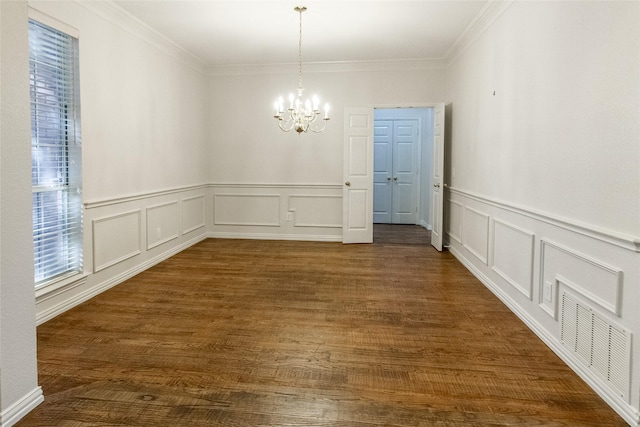 unfurnished dining area featuring dark hardwood / wood-style floors, ornamental molding, and an inviting chandelier